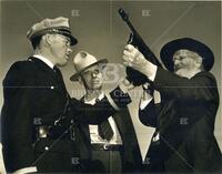 [Two old time Texas Rangers examine a modern Dept. of Public Safety automatic weapon]