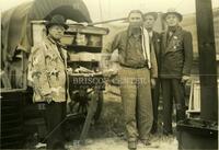 [Group of men standing in front of chuck wagon]